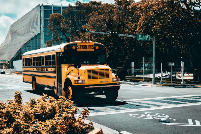 Yellow American school bus driving on a road