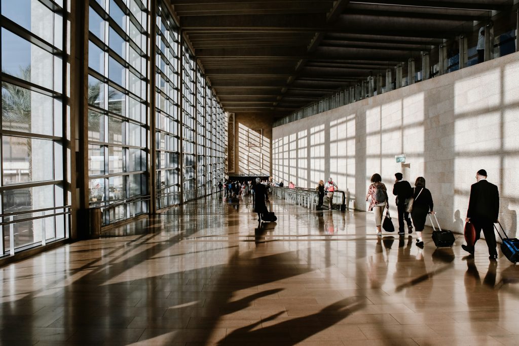 Suitcases and travelers moving through an airport terminal