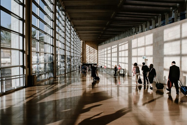 Suitcases and travelers moving through an airport terminal